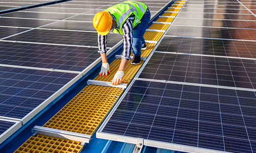 un professionnel en train d'installer des panneaux solaires sur un toit